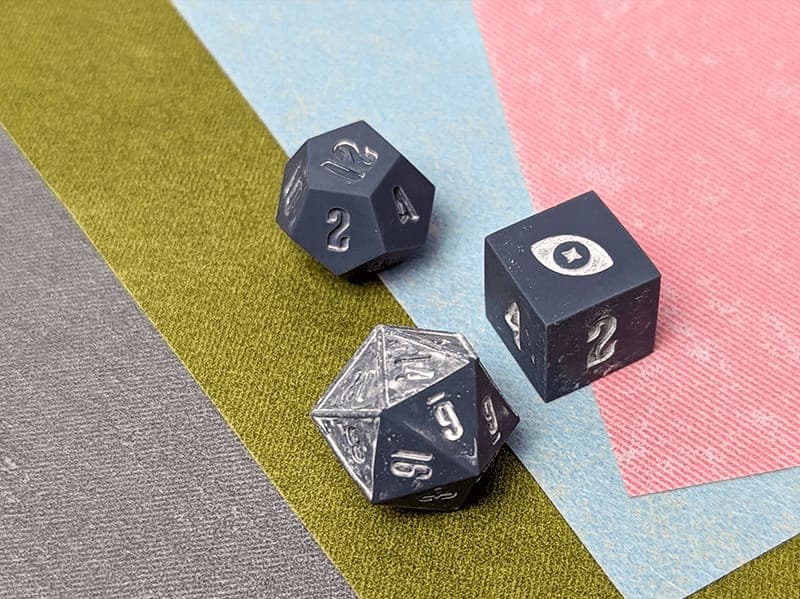 Master dice resting on sheets of sandpaper in different grits