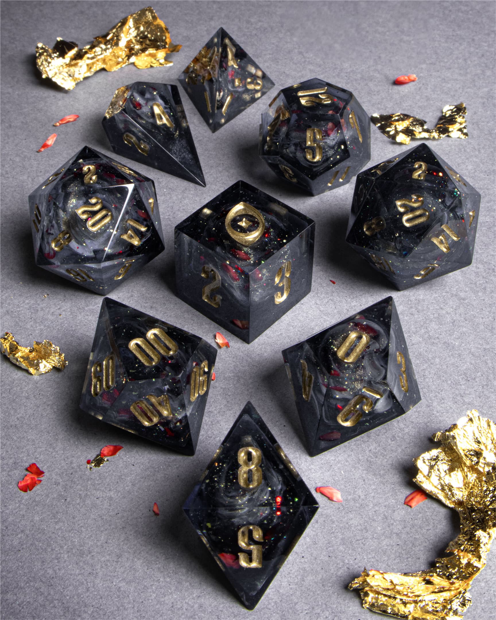 The Last Gommage Set, black resin with gray swirls, red flower petals, metallic foil, and golden numbers